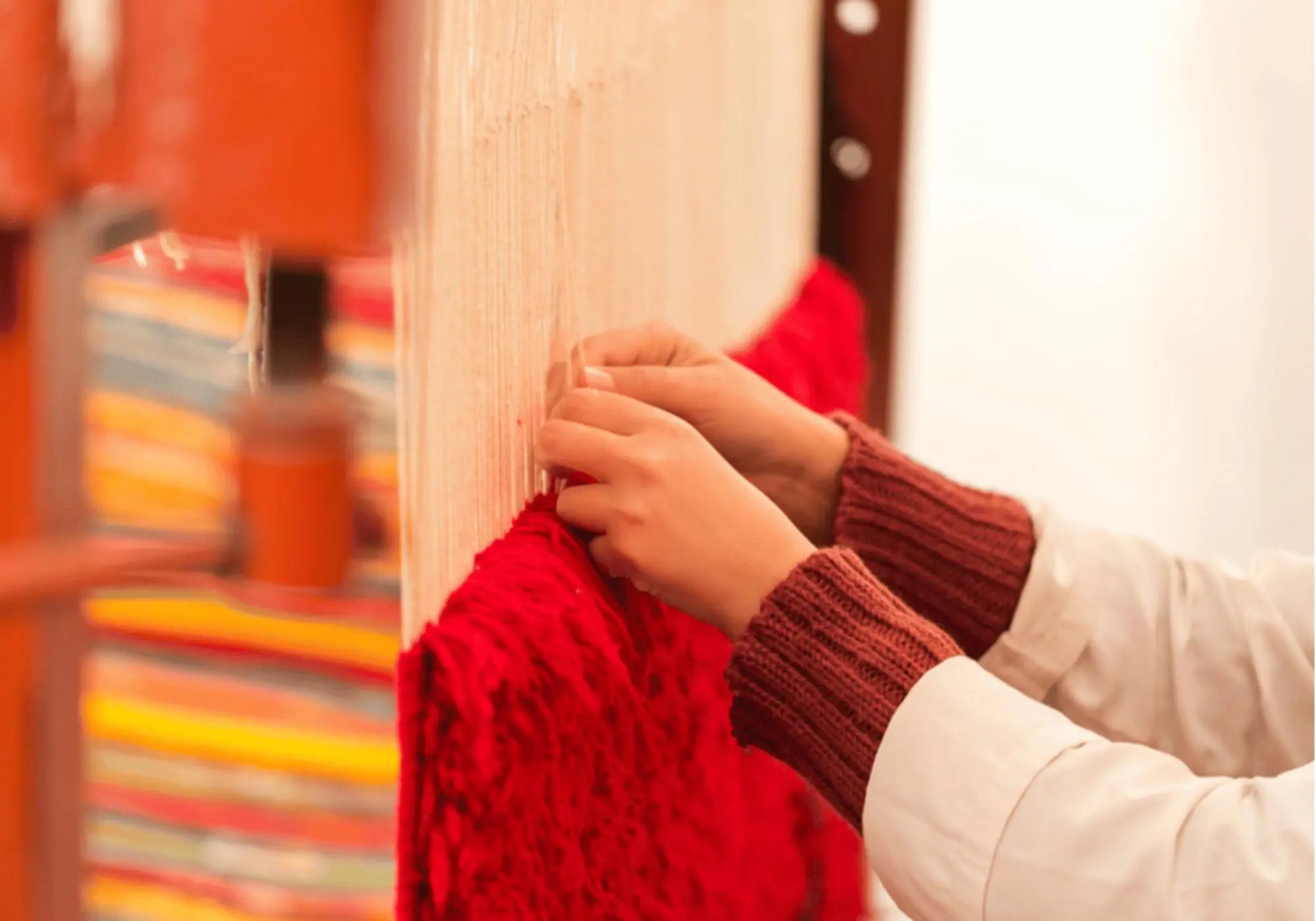 Artisane marocaine tissant à la main un tapis berbère en laine naturelle, savoir-faire traditionnel soutenu par Decoecoart