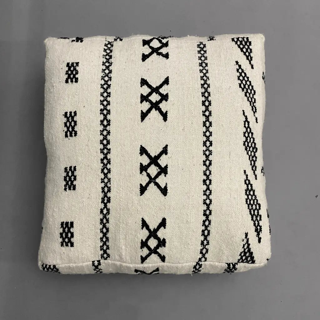 Coussin de sol berbère en laine naturelle – design artisanal marocain noir sur fond ivoire