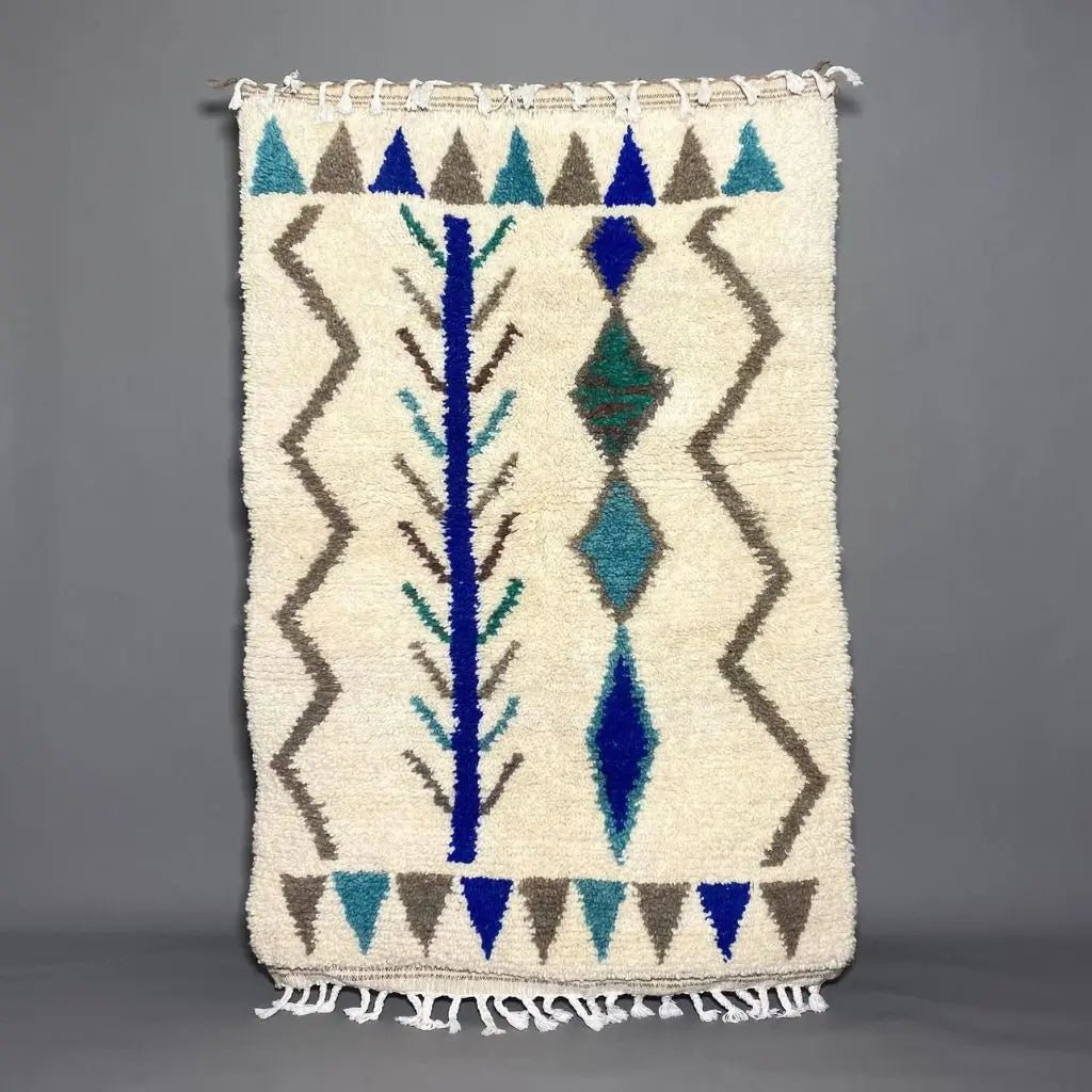 Tapis Azilal 164×107 cm en laine naturelle, couleurs vives et motifs bleus, tissage artisanal.