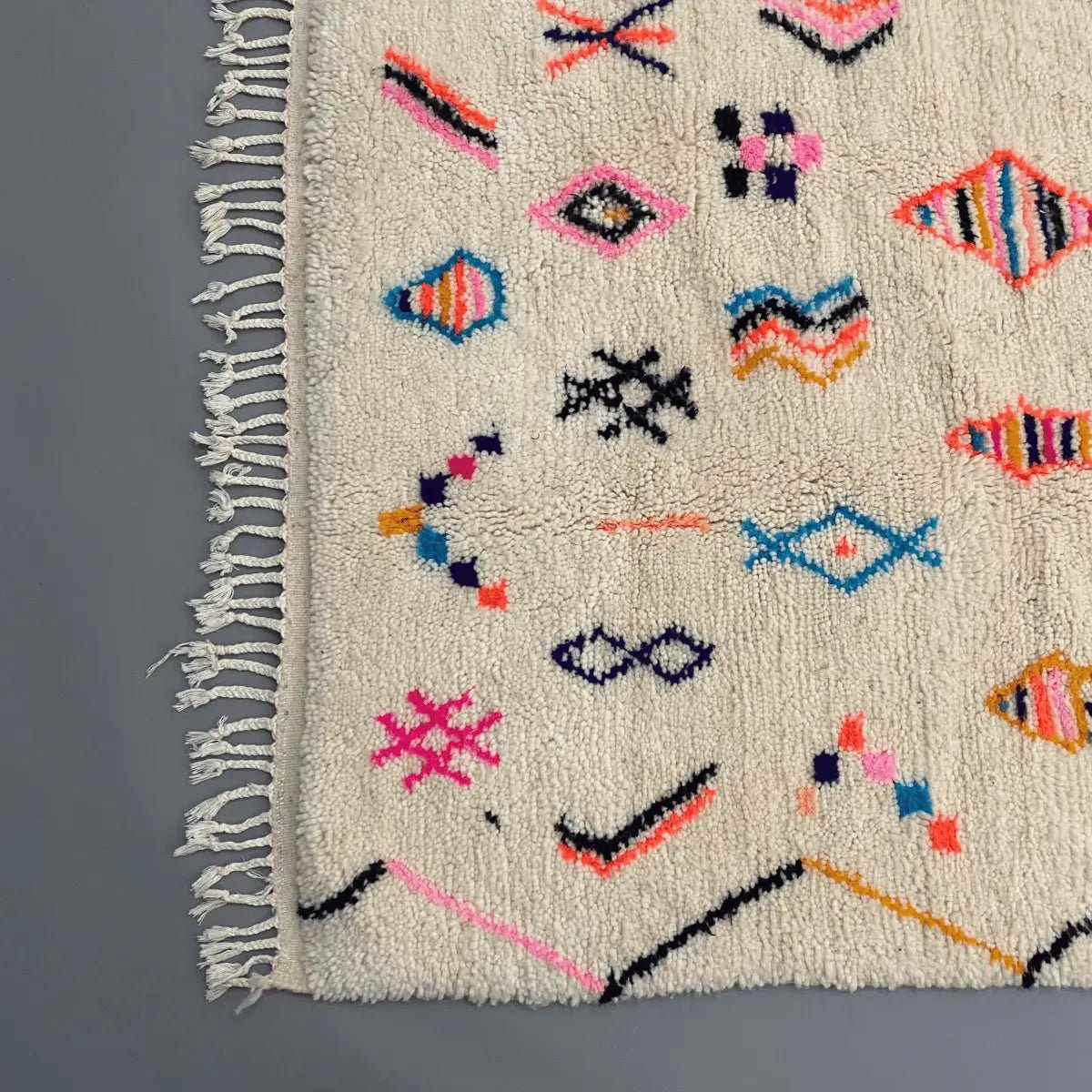 Détails Azilal coloré 260×160 cm, laine douce, franges tressées, motifs multicolores.