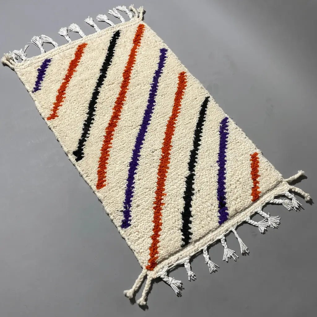Détail de la laine naturelle d’un tapis berbère coloré Azilal 101×59 cm, tissé artisanalement par des artisanes marocaines.