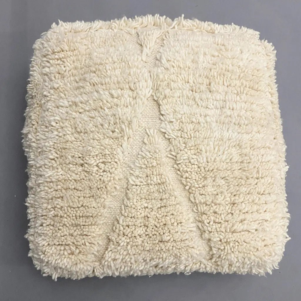 Pouf marocain en laine naturelle – texture moelleuse et tissage artisanal style Beni Ourain
