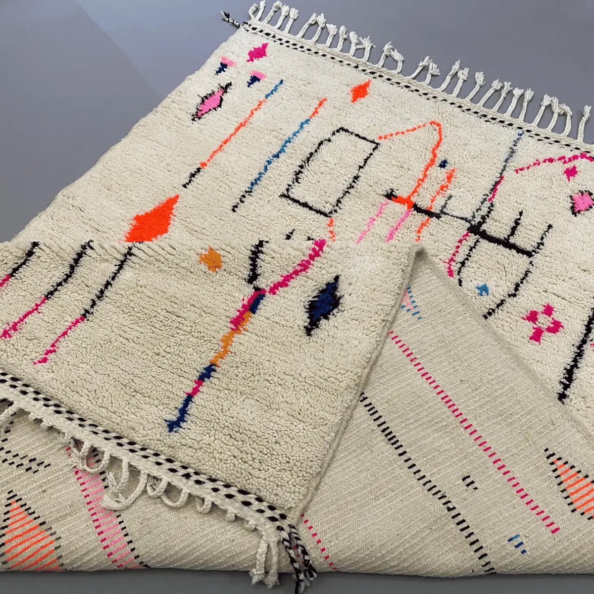 Finitions à franges du tapis Azilal ivoire – fabrication artisanale marocaine et détails colorés faits main